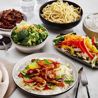 Assorted Asian-inspired dishes including noodles, stir-fried vegetables, beef, and rice bowls on a table.
