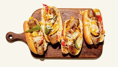 Sausage and pepper sandwiches topped with melted cheese, served on buns with roasted sweet peppers.
