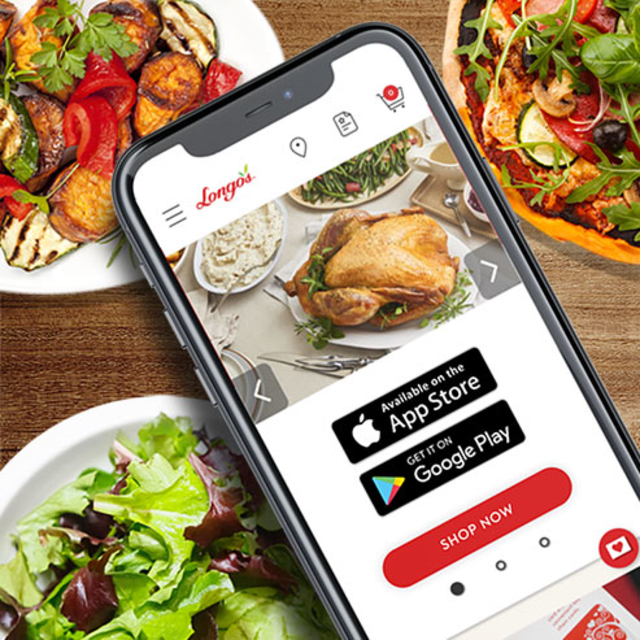 Smartphone displaying Longo&rsquo;s grocery app with roasted chicken image, surrounded by plates of salad and pizza.