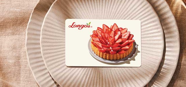 Longo&rsquo;s gift card featuring a strawberry tart, placed on plates with a pink napkin and a glass nearby.